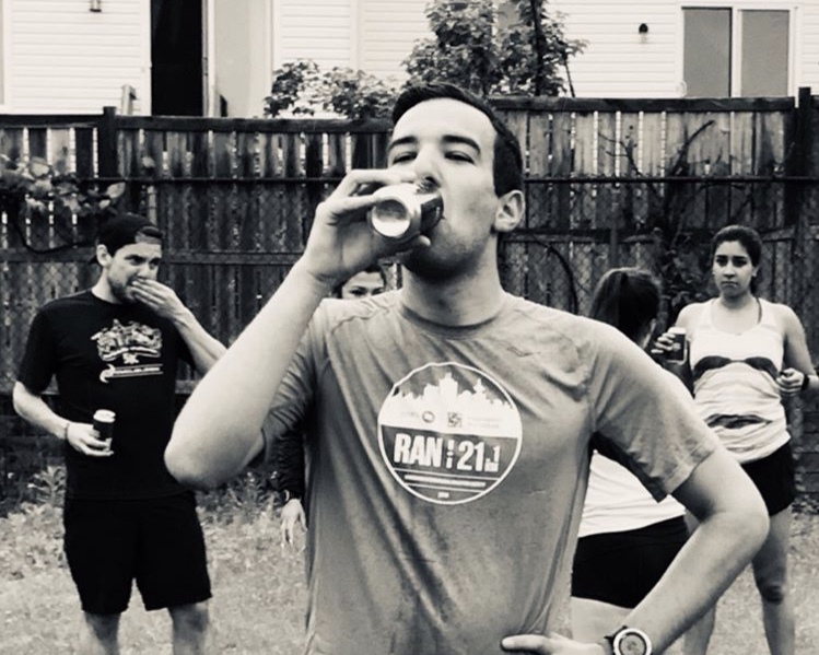 Grayscale photo of me during the OCRC 2019 Beer Mile, drinking a beer.